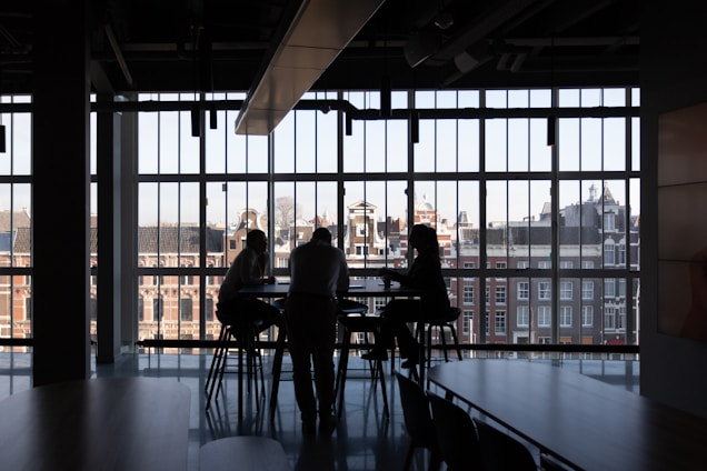 A confident team discussing investment plans around a table with city skyline visible through the window.