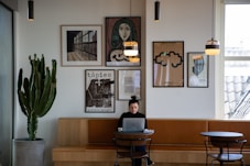 woman in black long sleeve shirt sitting on brown wooden chair