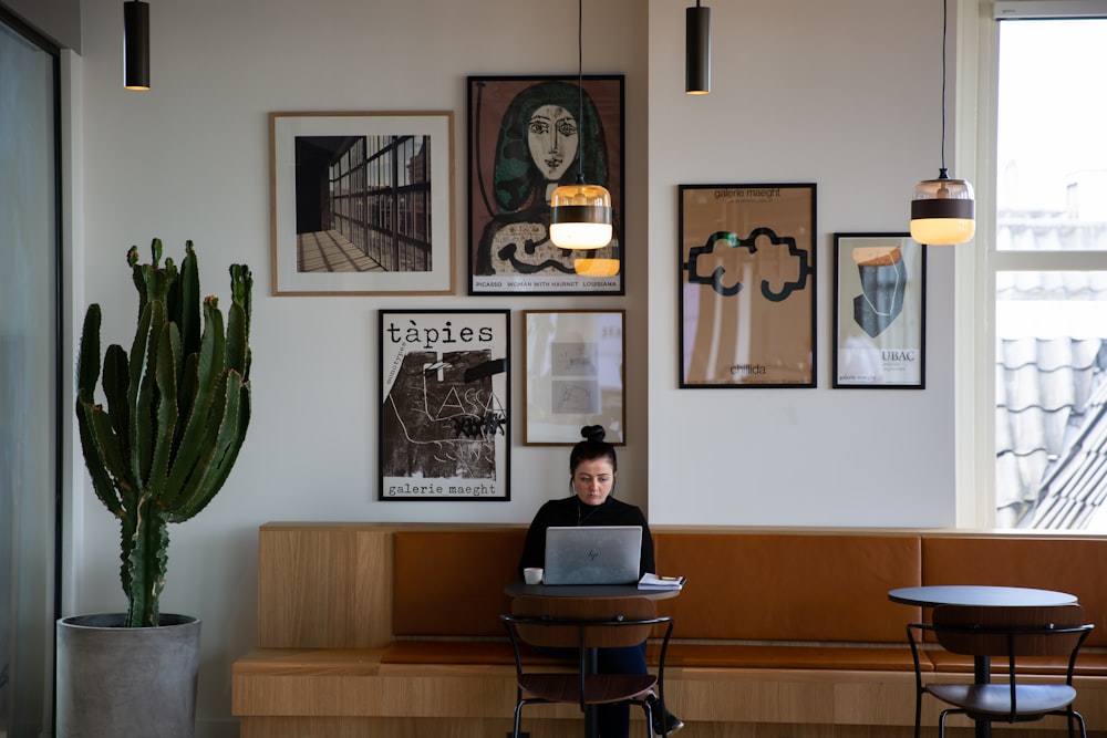 woman in black long sleeve shirt sitting on brown wooden chair