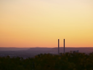 Sunset scene of charcoal kiln in operation with smoke gently rising in rural Jawa Timur.