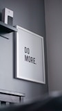 a picture hanging on a wall with a do more sign above it
