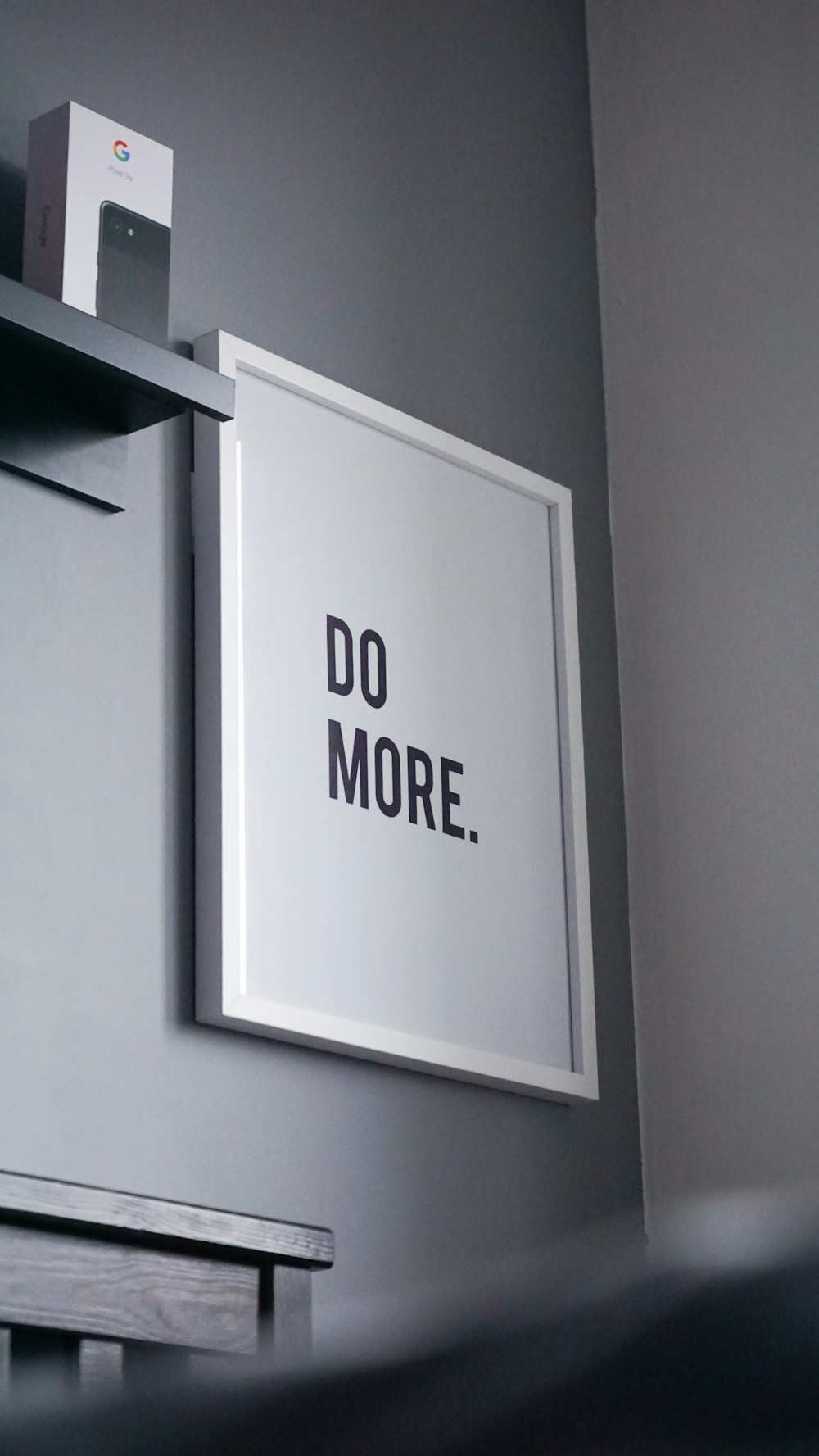 a picture hanging on a wall with a do more sign above it