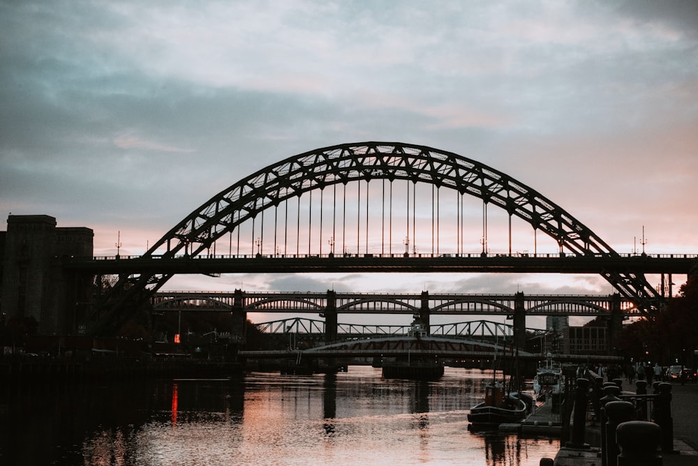 black metal bridge over body of water during daytime