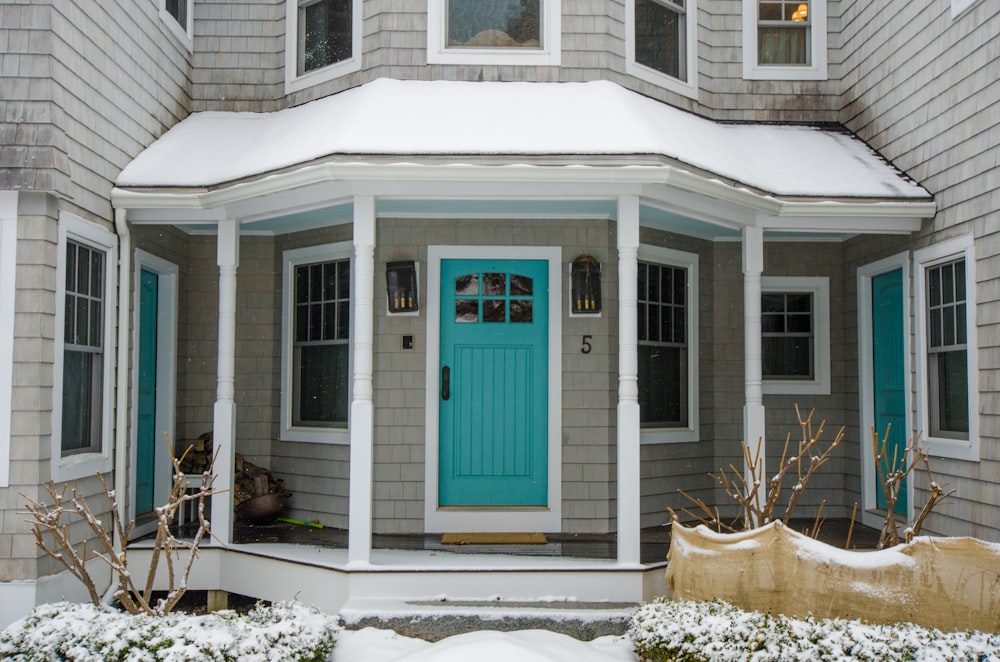 blue wooden door on white wooden house