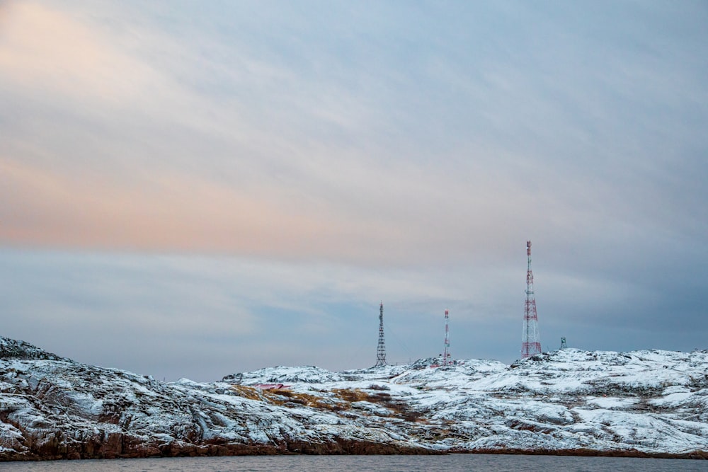 white and black wind turbines on gray rocky mountain under gray cloudy sky during daytime