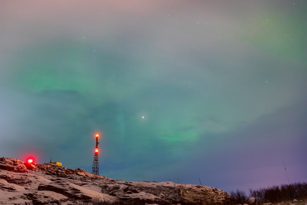 person standing on brown rock under green sky