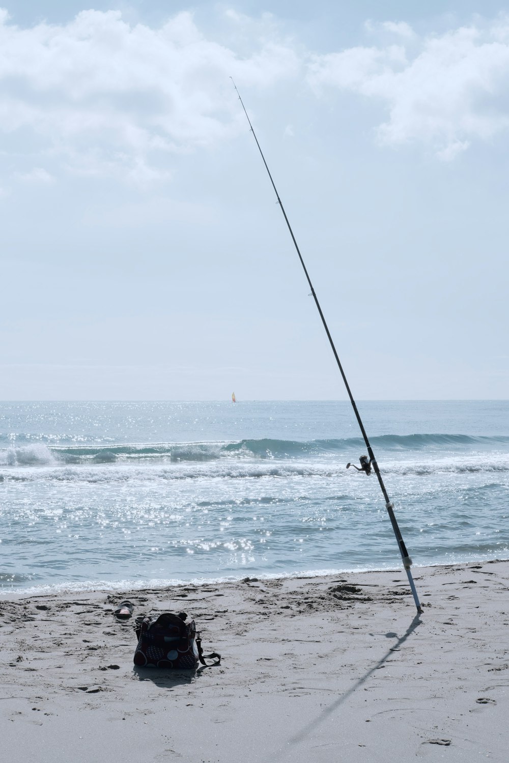 black fishing rod on seashore during daytime