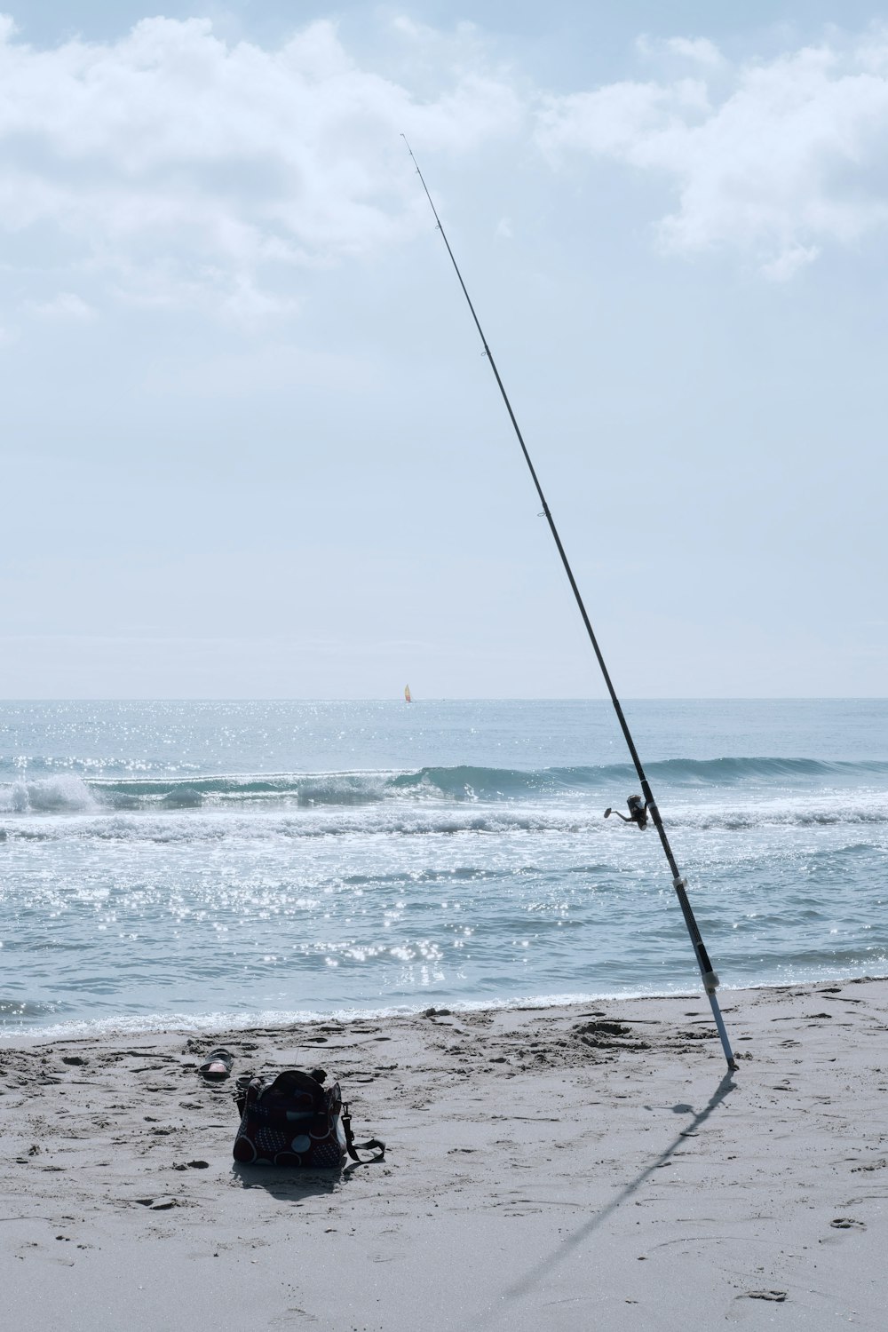 昼間の海岸の黒い釣り竿