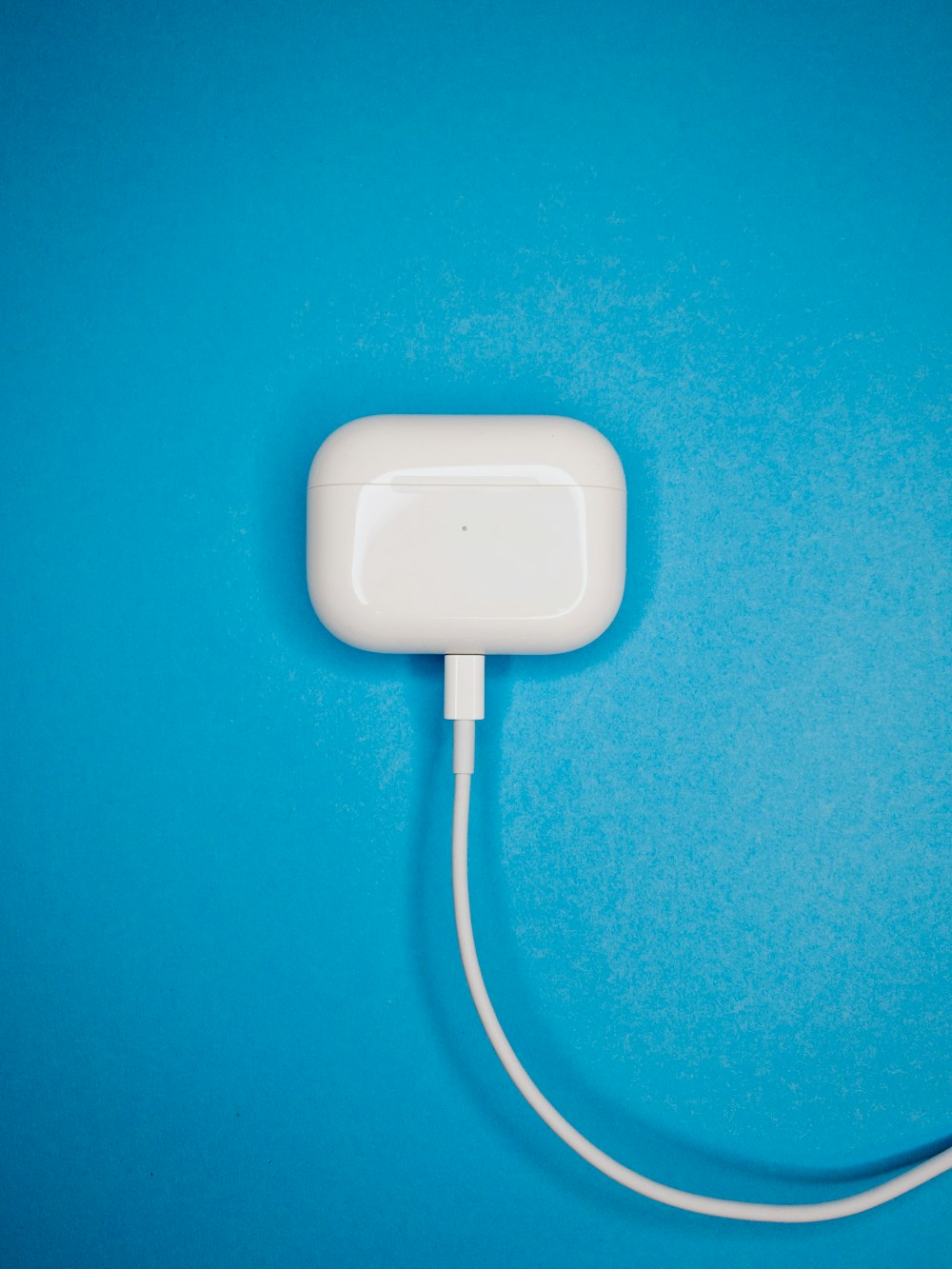 white charging adapter on blue surface