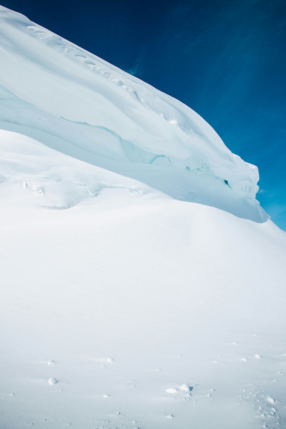 montanha coberta de neve branca sob o céu azul durante o dia