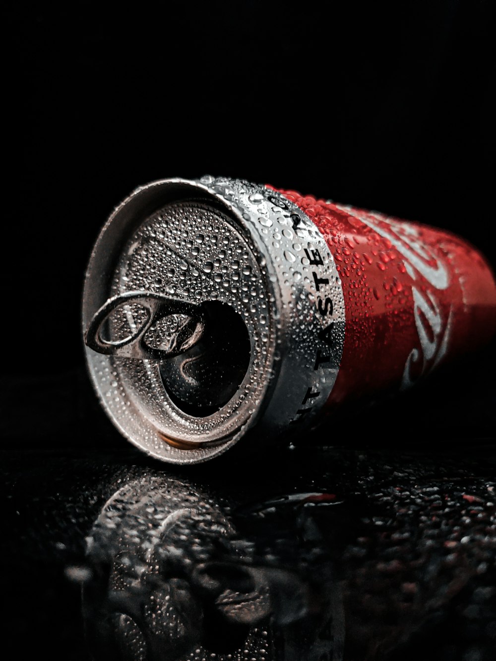 red and silver can on black surface