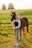 girl in white shirt and blue denim jeans standing on brown horse during daytime