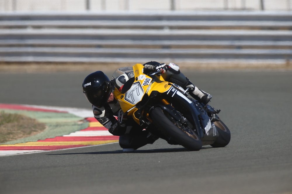 man in yellow and black motorcycle suit riding yellow and black sports bike