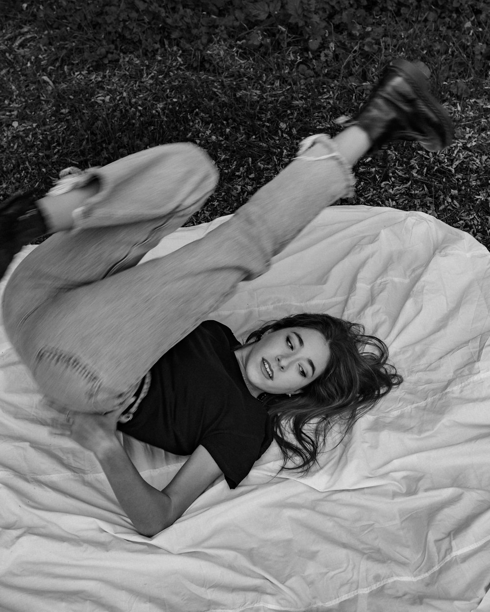 woman in black shirt lying on white textile