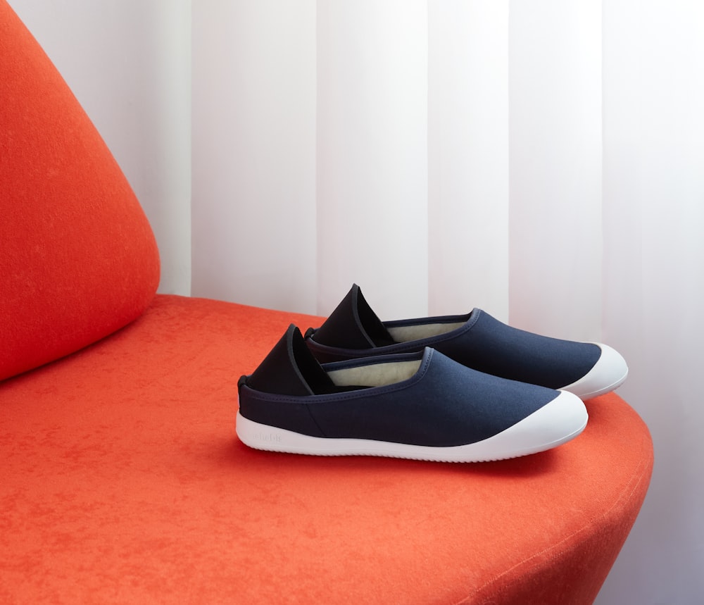 Scarpe slip on in bianco e nero sul divano rosso