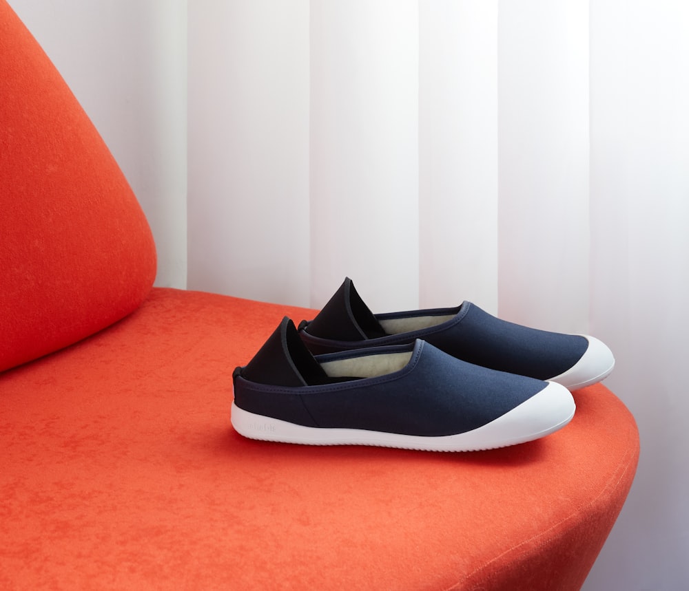 black and white slip on shoes on red sofa