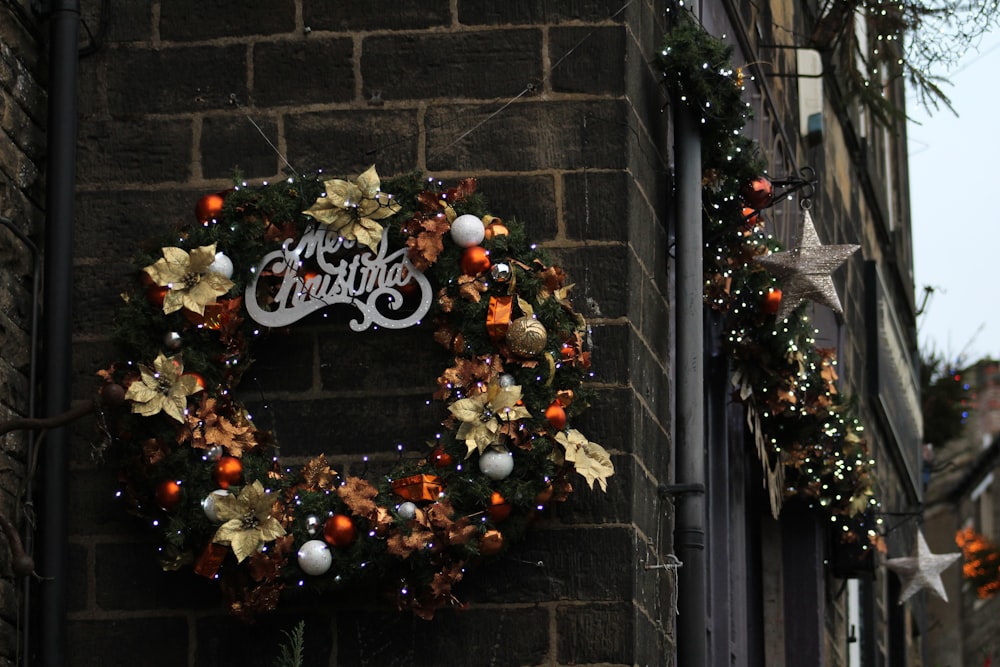 a christmas wreath hanging on the side of a building