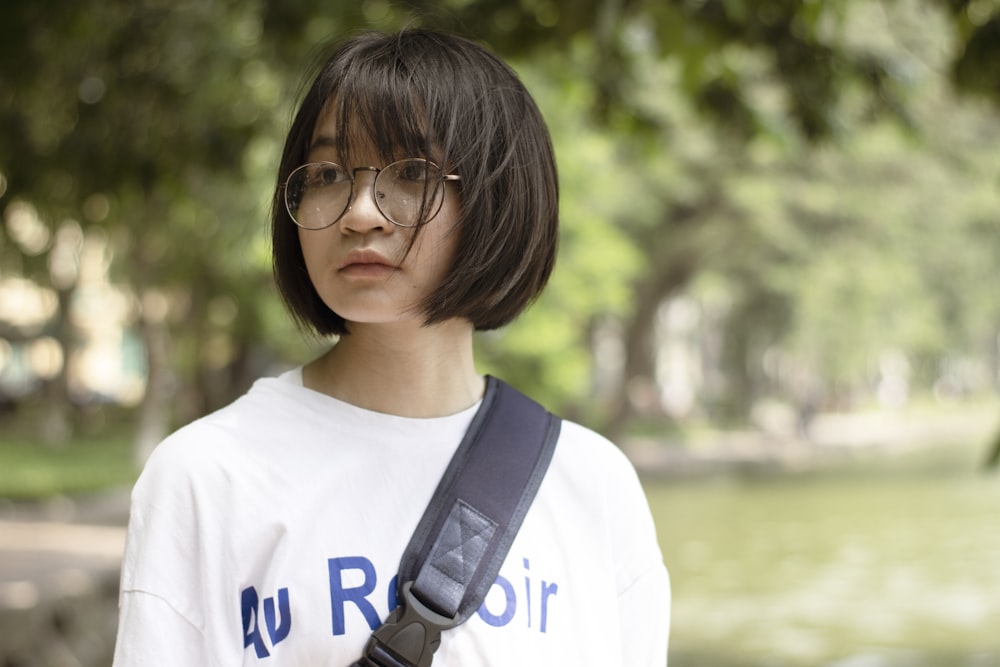 woman in white crew neck shirt wearing black framed eyeglasses