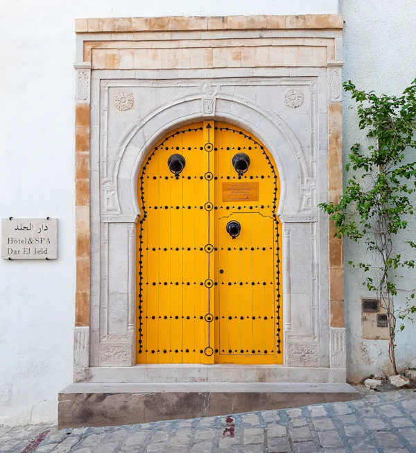 Porte traditionnelle tunisienne jaune à cadre en pierre