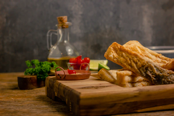 An outdoor kitchen scene featuring a teak cutting board with fresh seafood ready to be prepared.