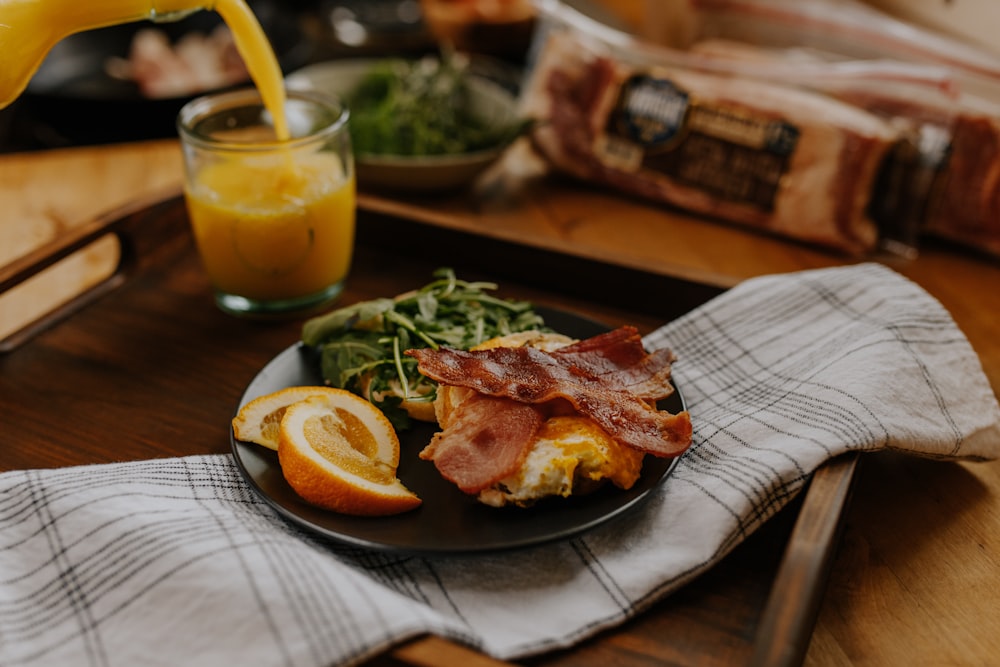 grilled meat with lemon and green vegetable on black plate