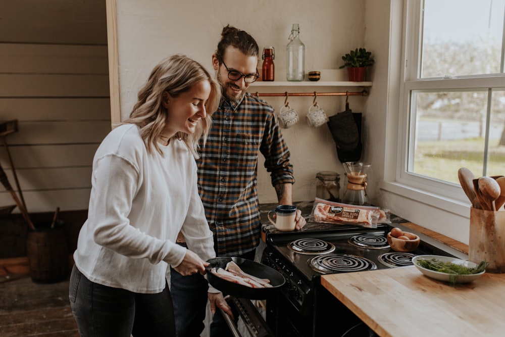 woman in white sweater holding black frying pan