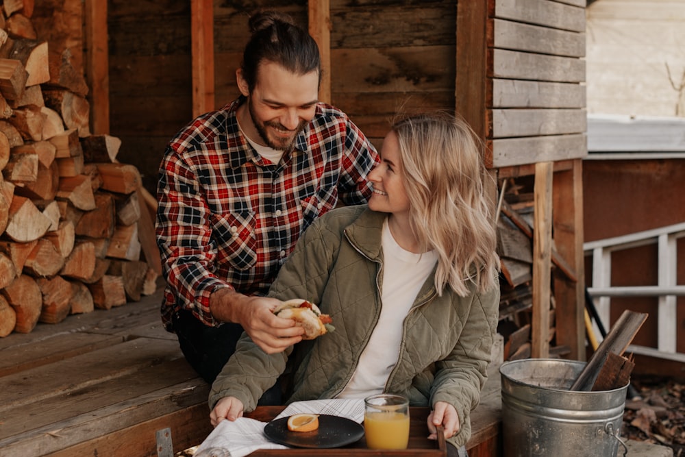 man and woman sitting on chair while eating