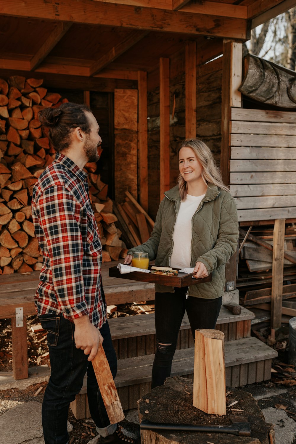 man and woman standing beside brown wooden fence