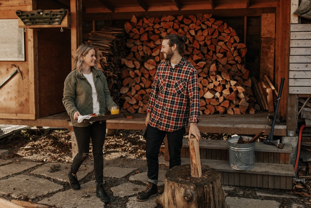 man and woman standing beside wood log
