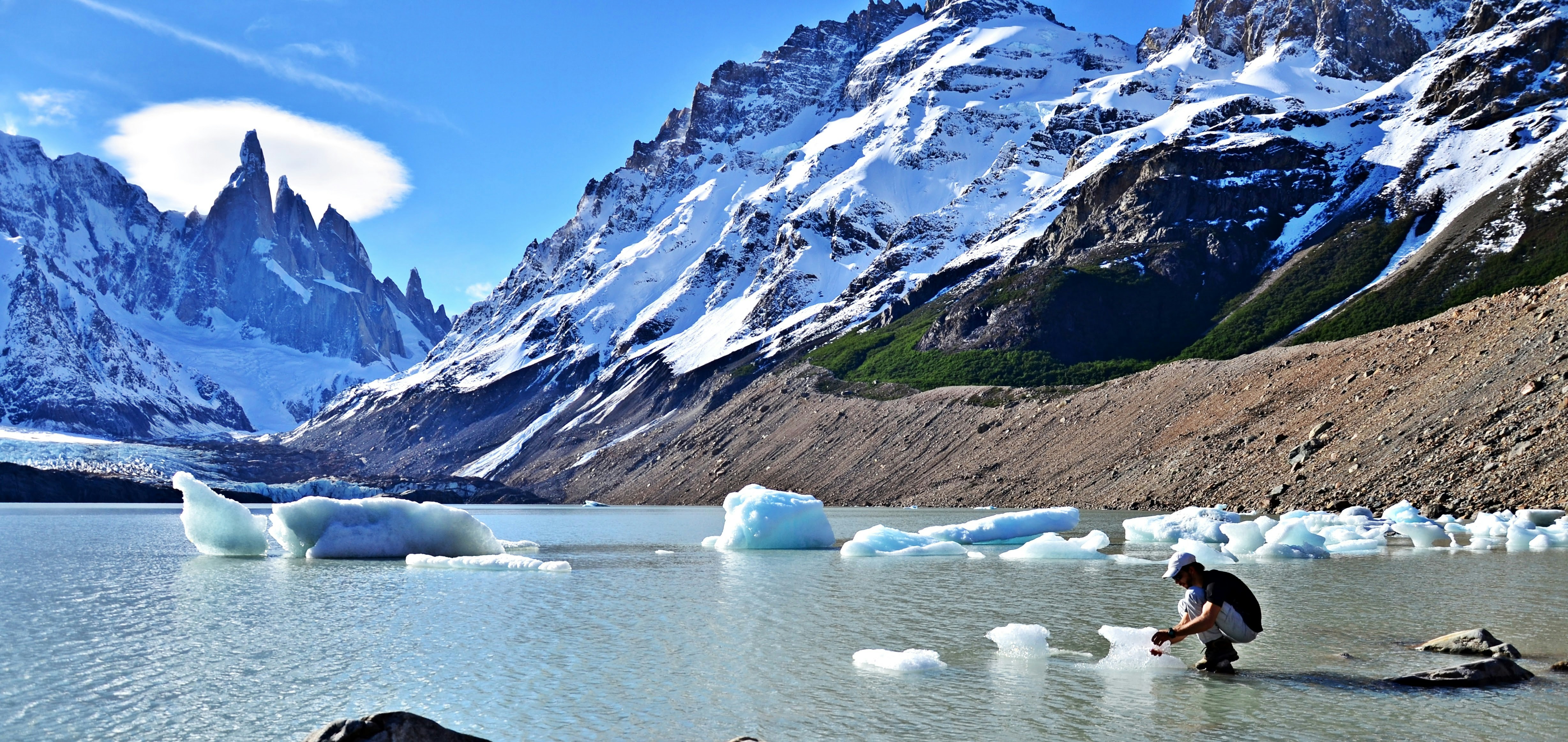 white ice on lake near snow covered mountain during daytime
