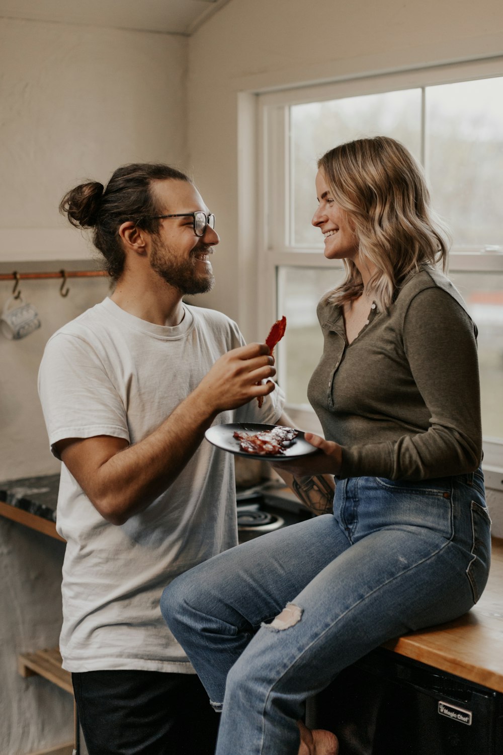 woman in gray crew neck t-shirt and blue denim jeans sitting on black chair