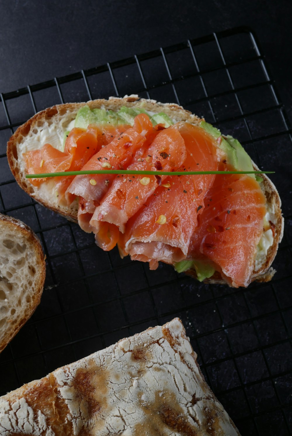 sliced bread with tomato and green vegetable on top