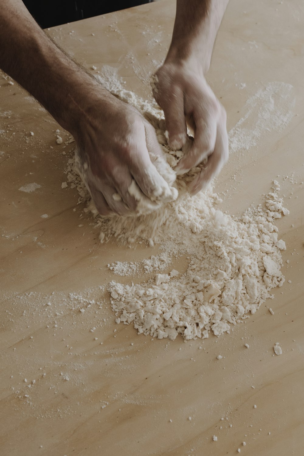 person making white powder on brown wooden table