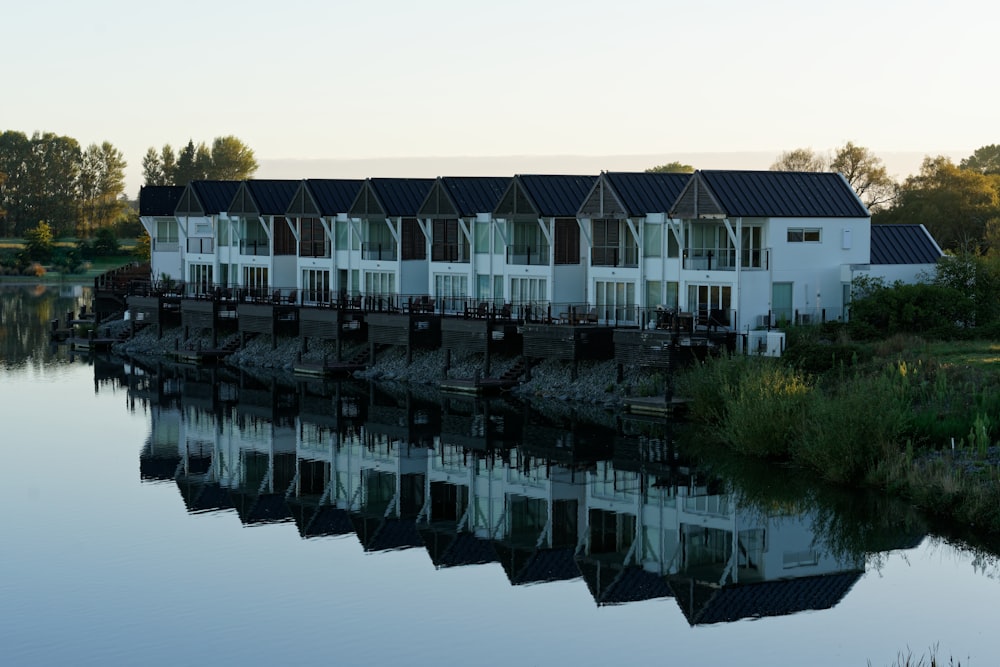 white and gray concrete building near green trees and body of water during daytime