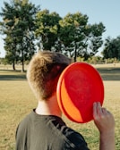 A colorful frisbee flying through a sunny park.