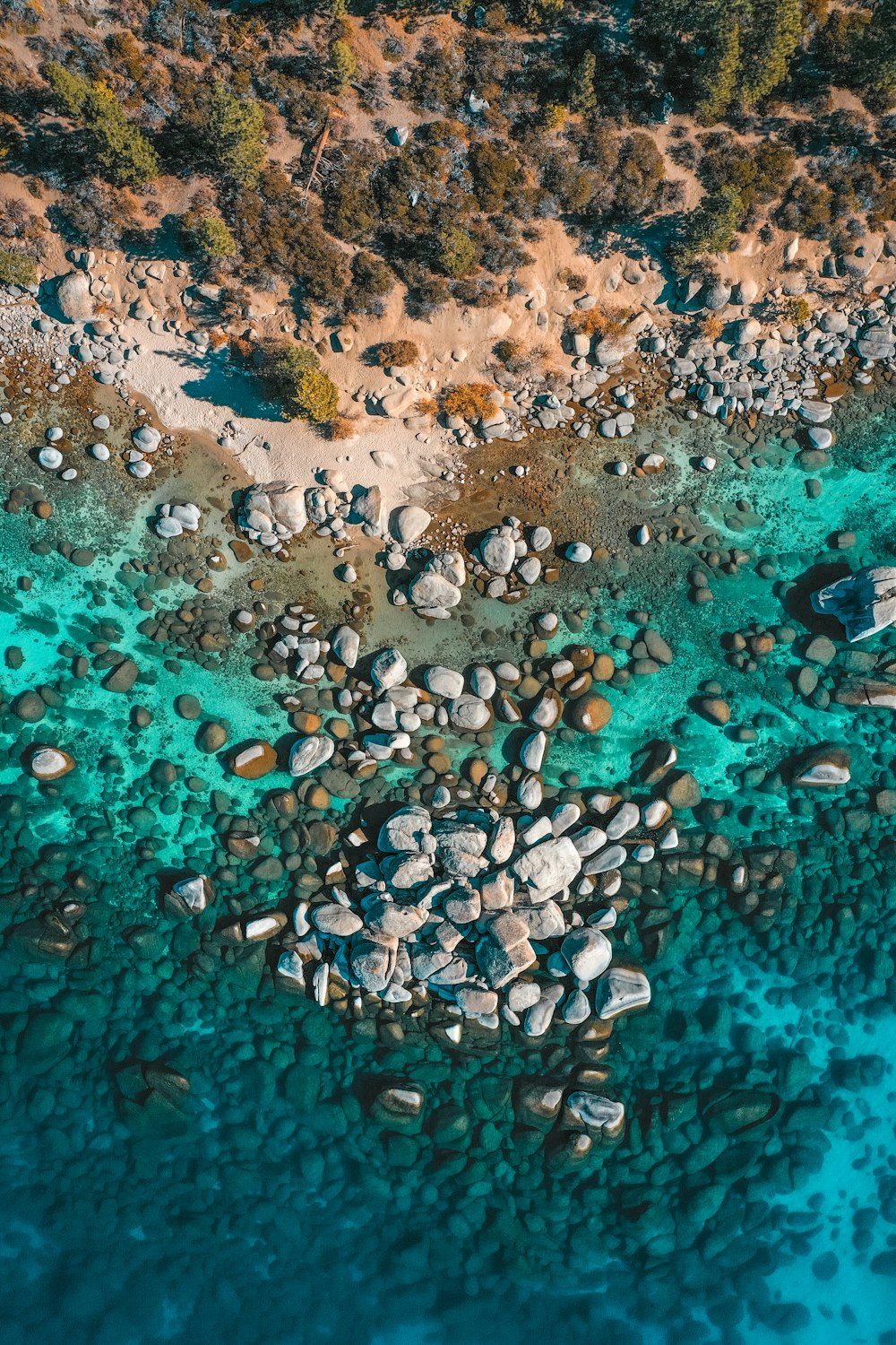 brown and black stone fragments on body of water