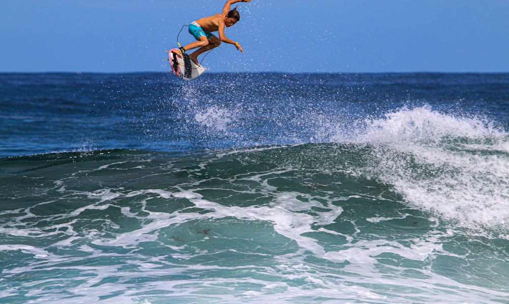 man in black shorts surfing on sea waves during daytime