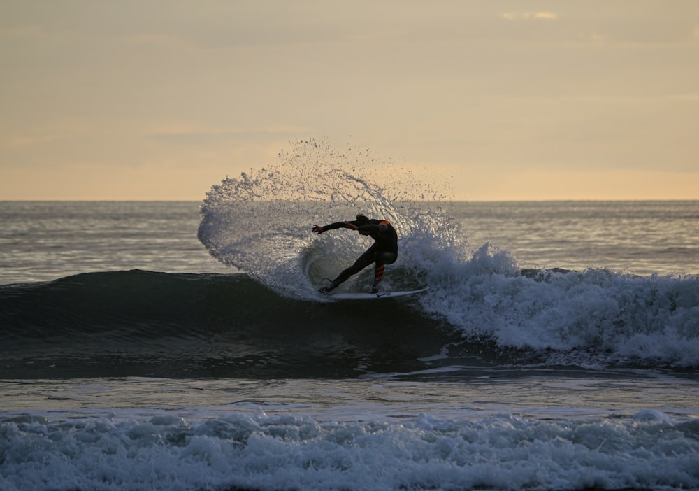 man surfing on sea waves during daytime
