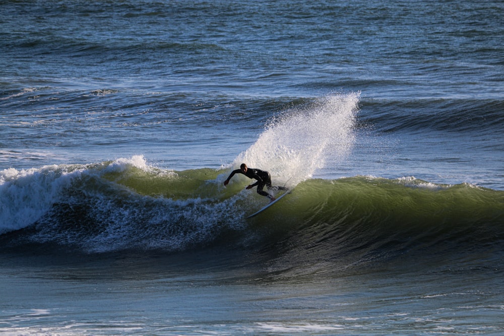 person surfing on sea waves during daytime