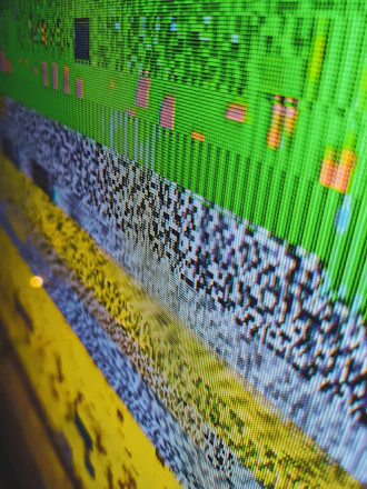 A close-up of a smartphone screen displaying a glitchy interface being fixed by a technician.