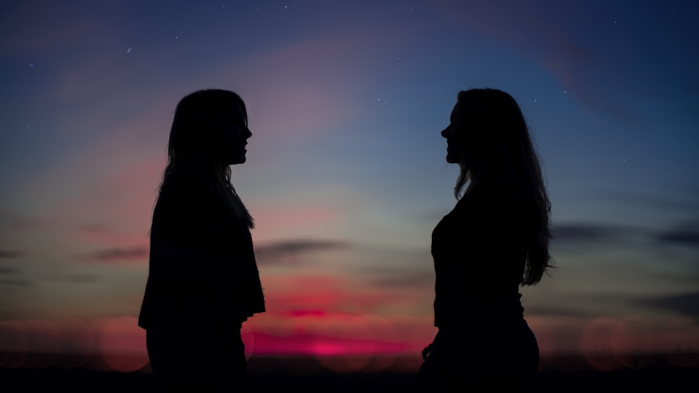 silhouette of man and woman kissing during sunset