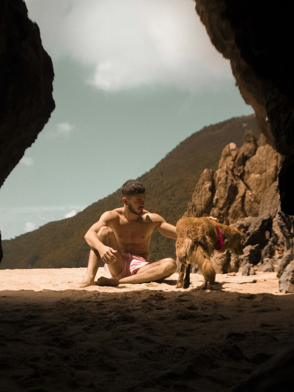 man sitting on brown rock formation during daytime