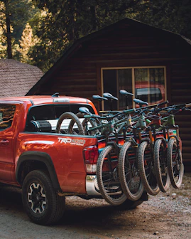 red chevrolet crew cab pickup truck parked beside black bicycle