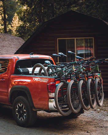 red chevrolet crew cab pickup truck parked beside black bicycle
