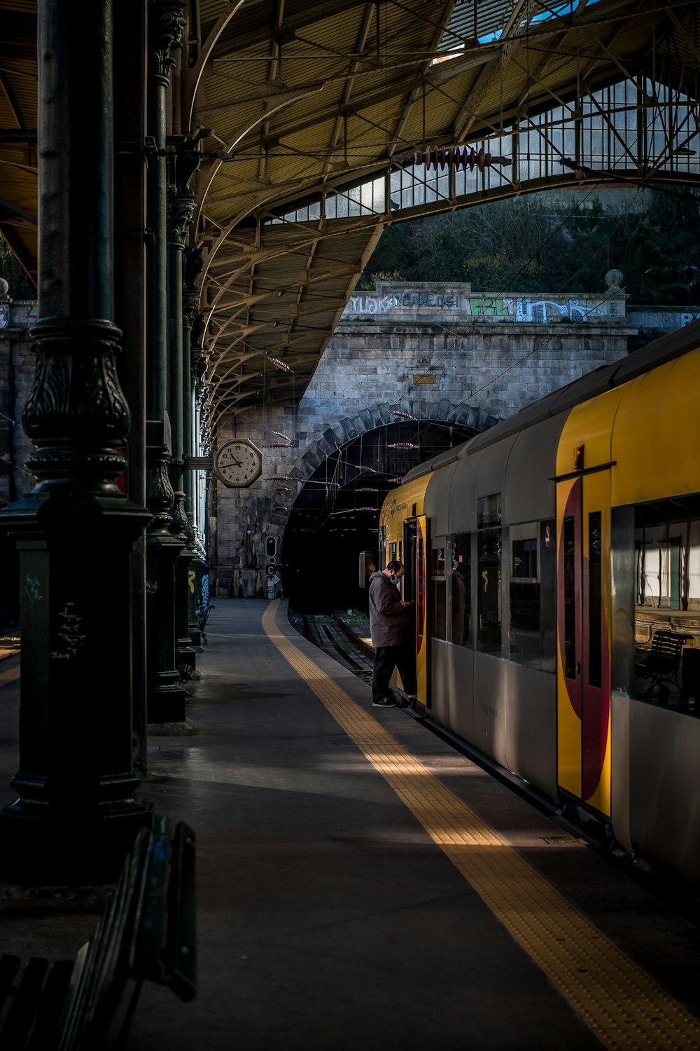 personnes debout à côté du train jaune pendant la journée