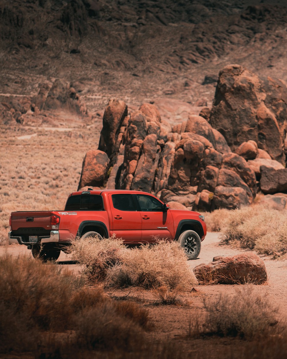 red and black jeep wrangler on brown dirt road during daytime