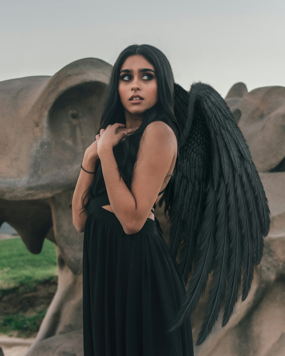 Femme en robe noire sans manches debout à côté de Brown Rock