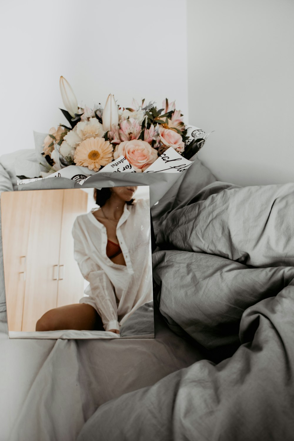 woman in white long sleeve shirt sitting on gray couch