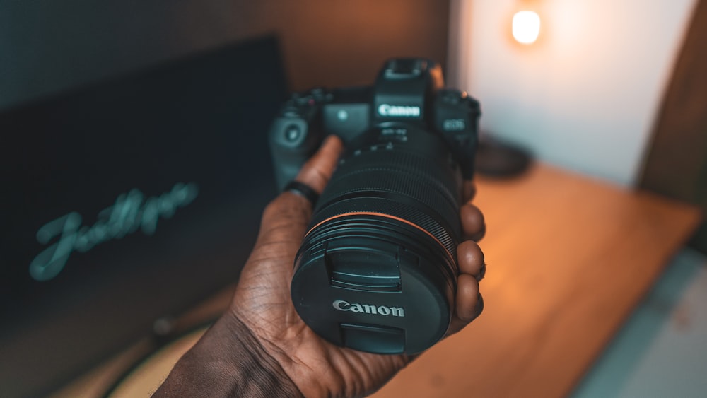 person holding black nikon dslr camera