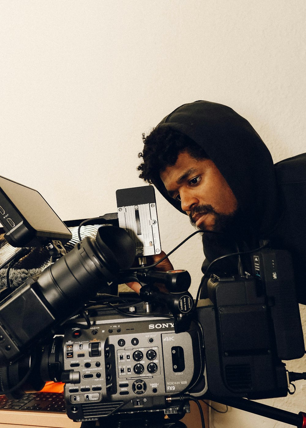 man in black hoodie using black and gray audio mixer